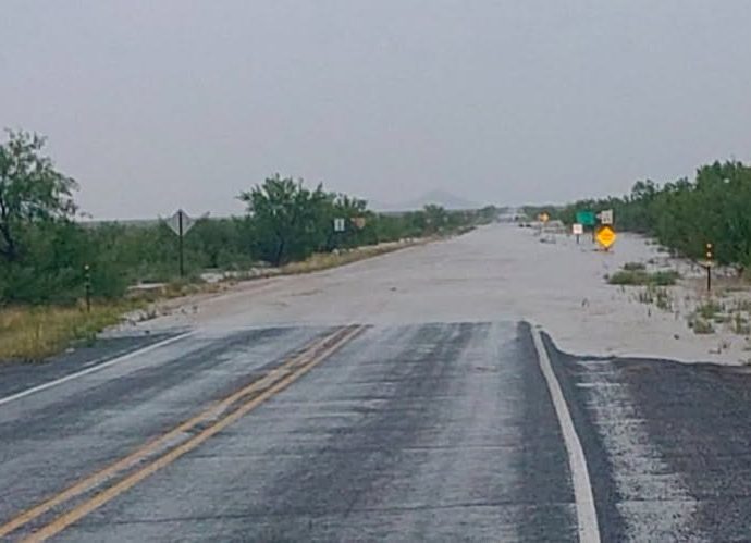 NMDOT District One maintenance crews responding to flood damage and debris along a southwestern New Mexico roadway after heavy rainfall.
