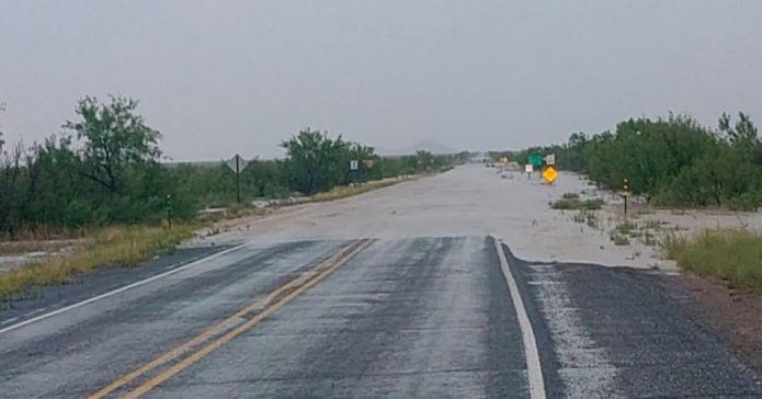 NMDOT District One maintenance crews responding to flood damage and debris along a southwestern New Mexico roadway after heavy rainfall.