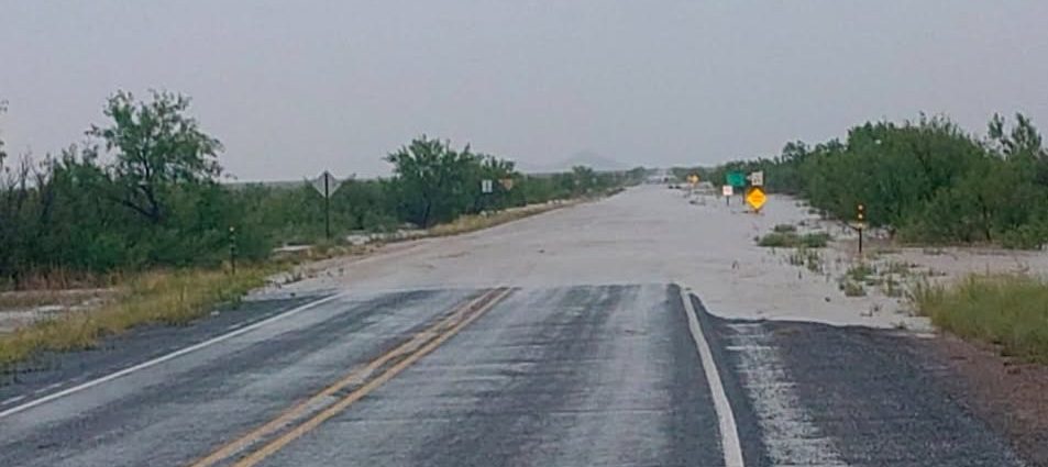 NMDOT District One maintenance crews responding to flood damage and debris along a southwestern New Mexico roadway after heavy rainfall.