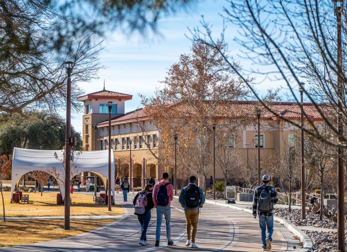Students walk across the New Mexico State University campus in Las Cruces.