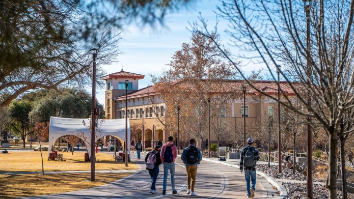 Students walk across the New Mexico State University campus in Las Cruces.
