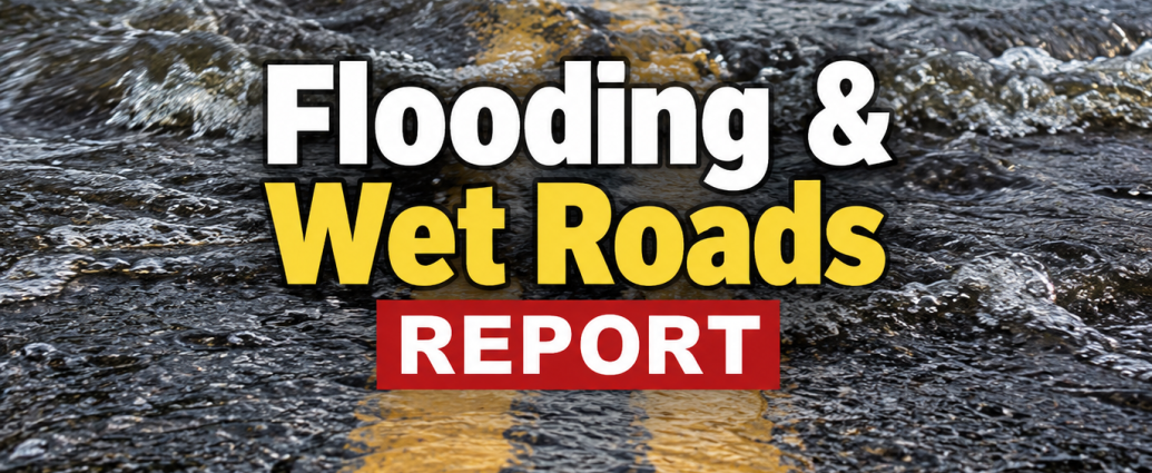 Flood water running across a two-lane highway during wet road conditions