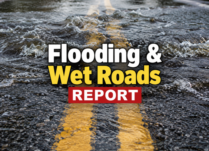 Flood water running across a two-lane highway during wet road conditions