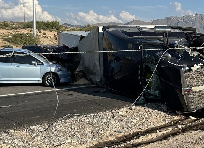 An overturned semi-truck and a car at a crash scene near Anthony.